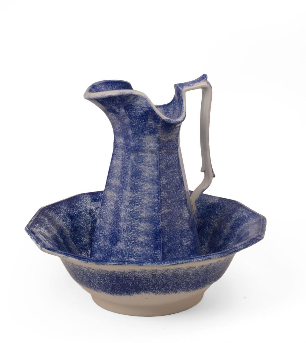 Blue ceramic pitcher with a curved handle and pouring spout, paired with a matching blue wash basin bowl.