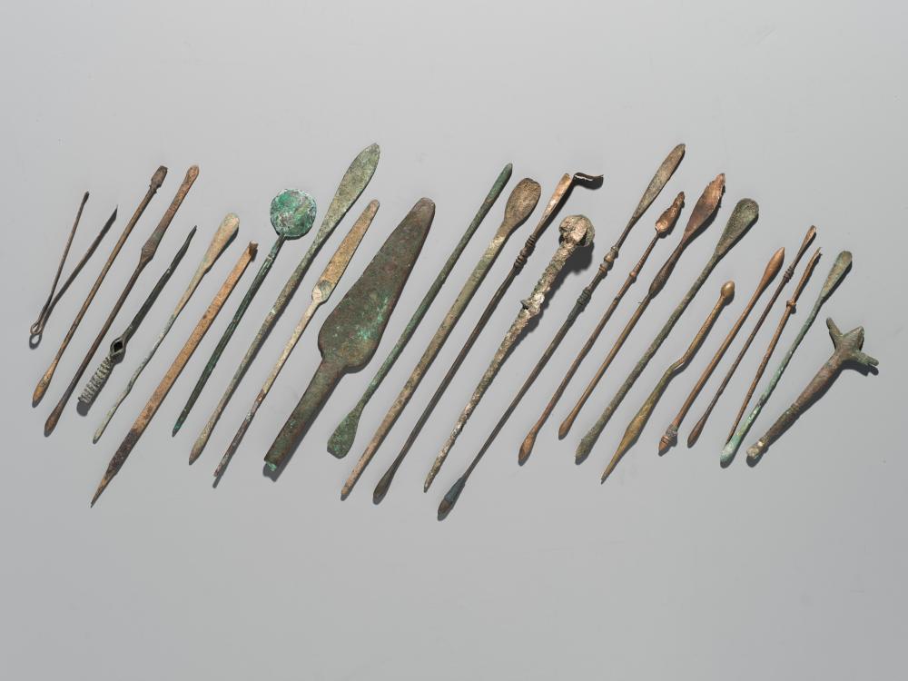 A GROUP OF TWENTY-FOUR GREEK AND ROMAN BRONZE PINS, SPOONS AND TOOLS, 1ST MILLENNIUM AD AND EARLIER sold by Galerie Zacke, lot 173 — auction record photograph