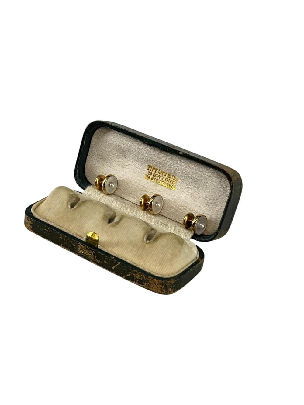Three gold-tone tuxedo shirt buttons with round white mother-of-pearl centers displayed in a small vintage box.