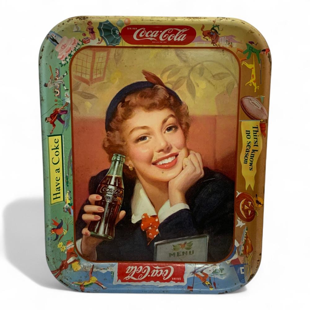Coca-Cola vintage advertising tin tray with a smiling woman holding a Coca-Cola bottle, surrounded by colorful graphics.