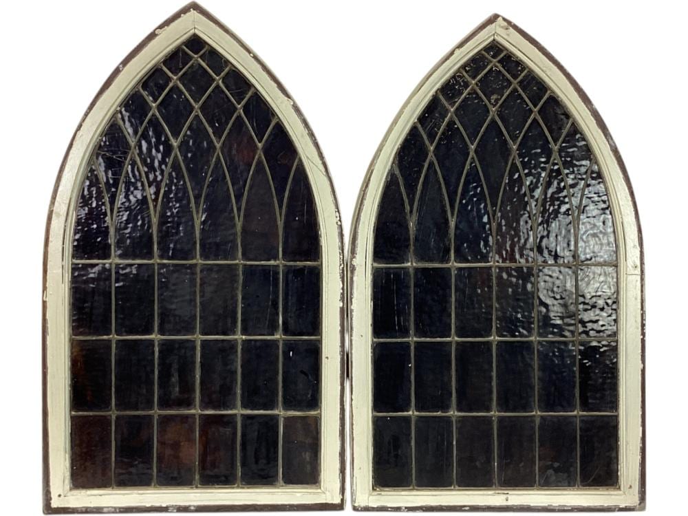 Photo of a pair of arched window panes with dark blue stained glass and a grid of leaded bars.