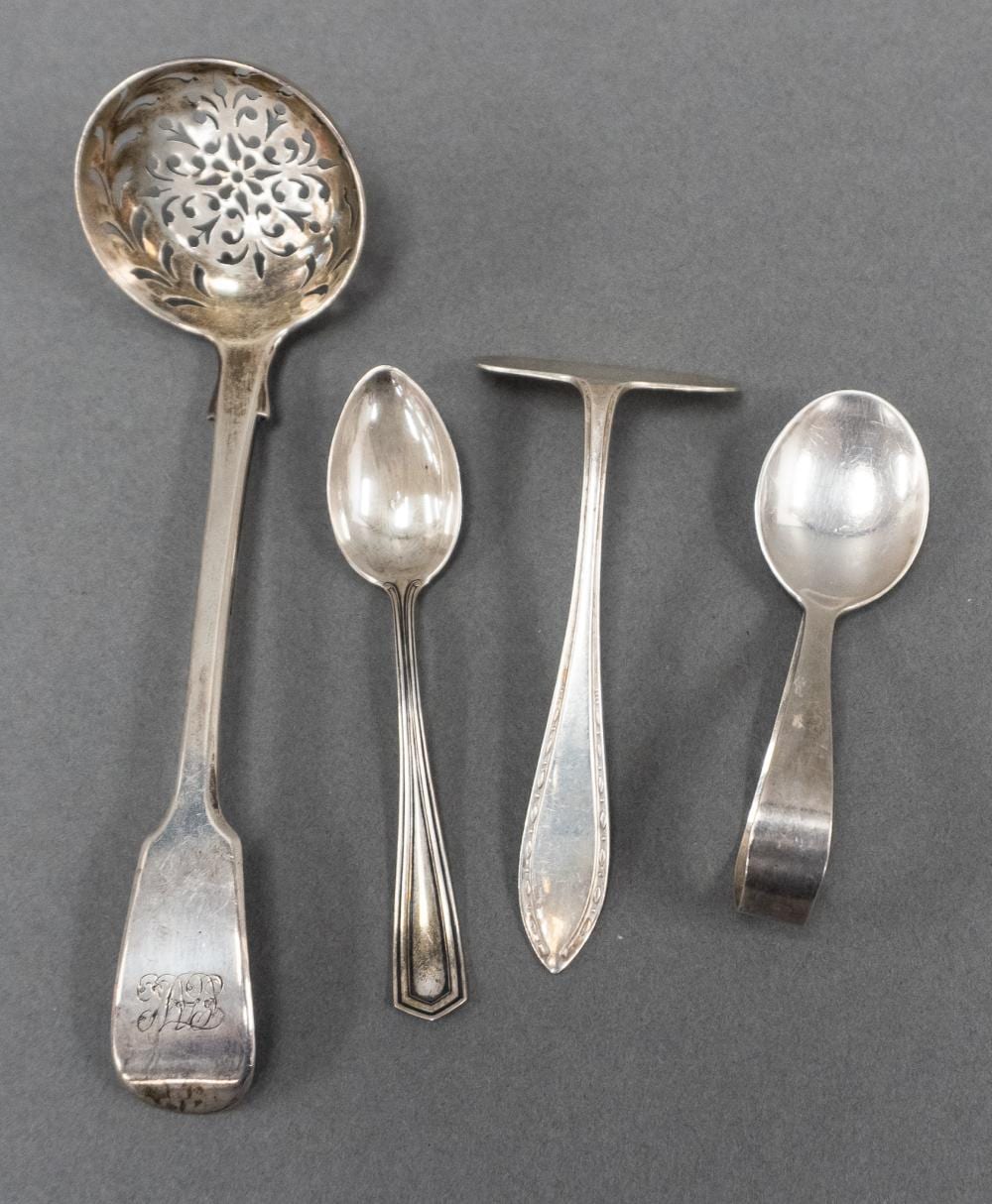 Four silver-colored serving spoons and ladles arranged side by side, including one pierced ladle with decorative bowl pattern.