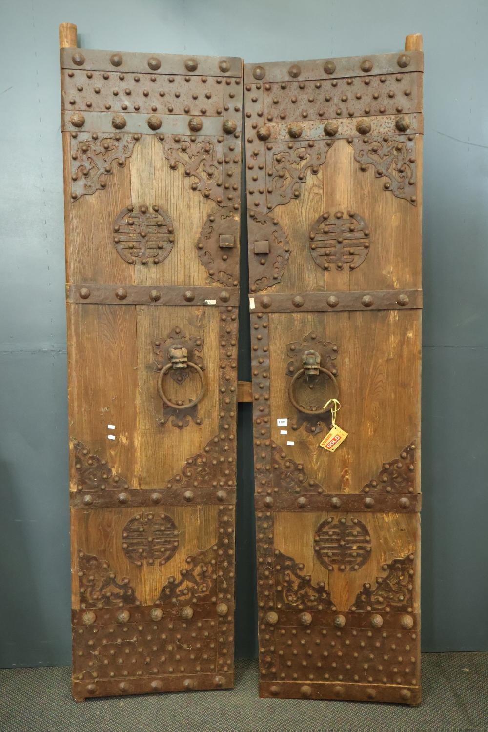 PAIR OF ANTIQUE CHINESE ELM COMPOUND DOORS WITH CAST IRON KNOBBED CLADDING AND FOO DOG RING PULL HANDLES, CONSTRUCTED WITH HAND FORGED NAILS, VERY HEAVY, APPROX. 223CM X 53CM EACH sold by Albion Antique Auction Centre, lot 1381 — auction record photograph