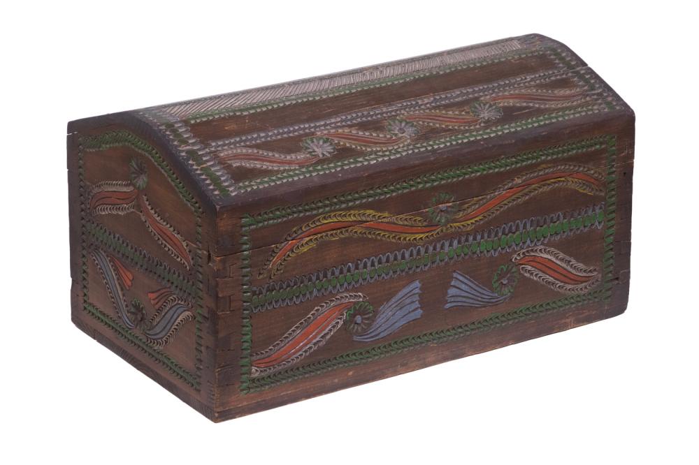 Wooden trunk with a domed top and carved panels decorated with multicolor geometric and scroll patterns.