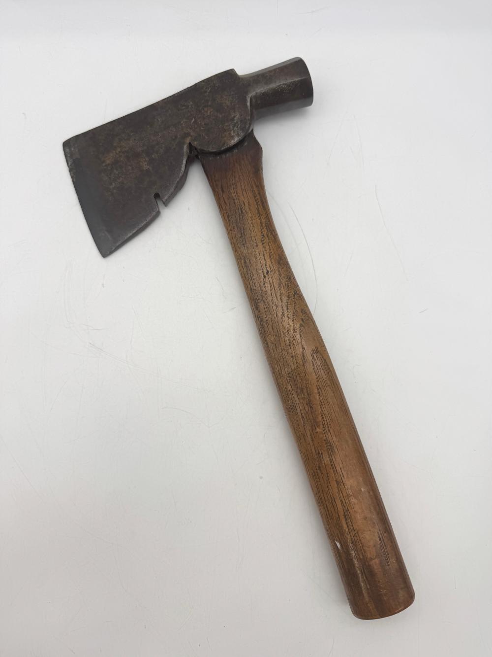 Vintage hatchet with a dark metal head and a wooden handle, shown on a white background.