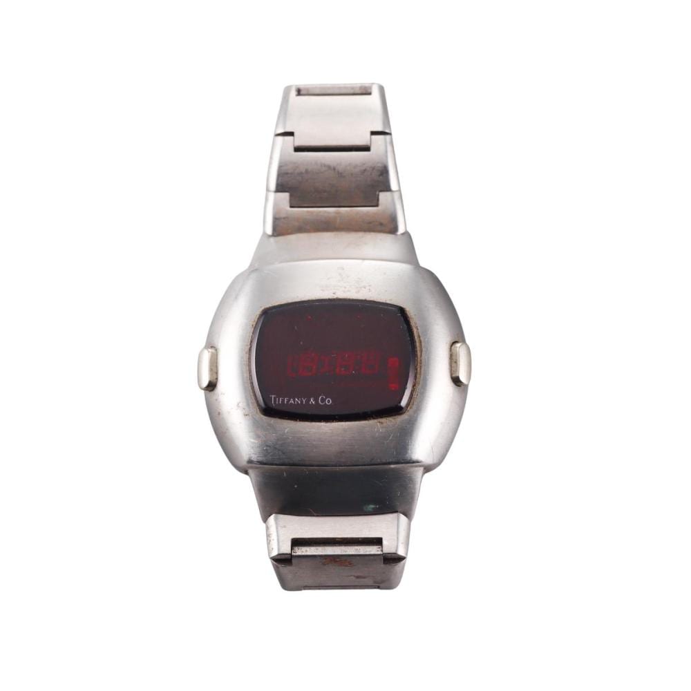 Close-up of a vintage-style stainless steel wristwatch with a rectangular dark digital display showing red numbers and a “Tiffany & Co” logo.