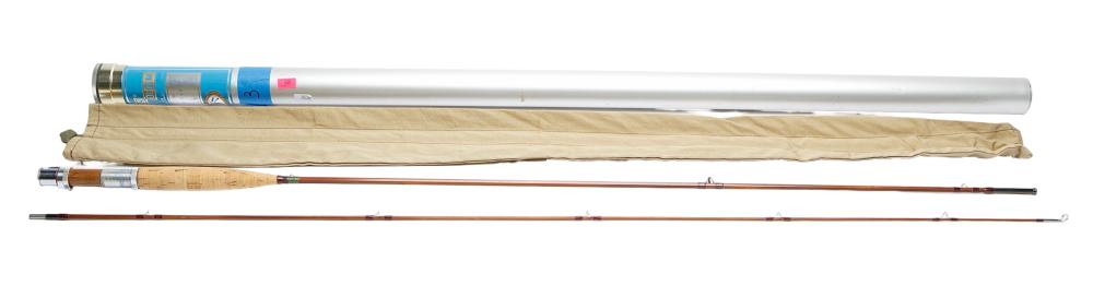 Vintage fly fishing rod laid horizontally with a cloth sleeve and a blue-and-white label near the handle end.