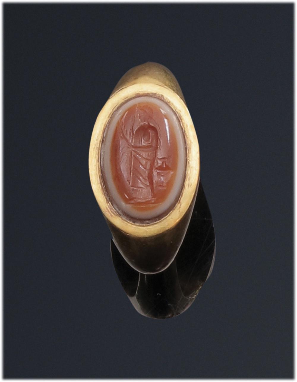 Bague en or jaune à chaton ovale sertie d'une intaille ovale en agate trois couches gravée d'un personnage archaïsant debout vers la gauche, tenant un branchage. sold by Phidias, lot 2 — auction record photograph