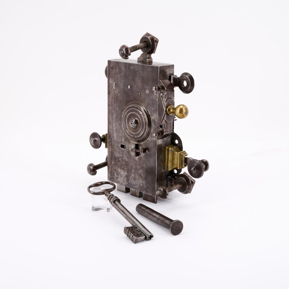 Large metal door lock mechanism with two circular knobs and a hollow pin key on a white background.