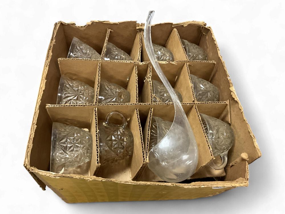 Cardboard tray holding a vintage punch bowl set with several embossed glass cups and a handled glass punch bowl.