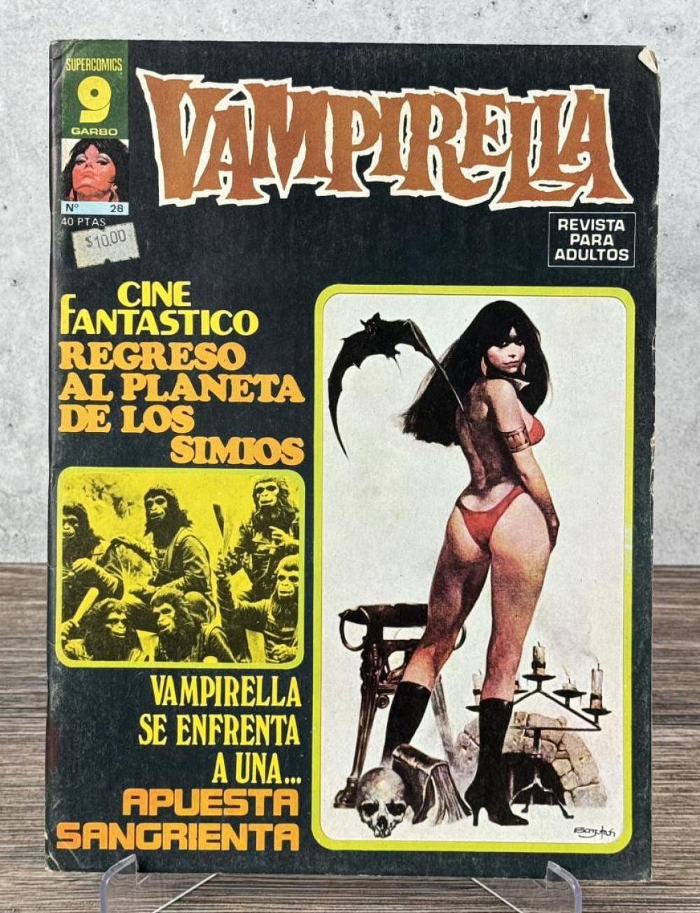 Front cover of a Spanish comic book titled "Vampirella" featuring a woman in a red bodysuit holding a gun and standing with bats and candles.