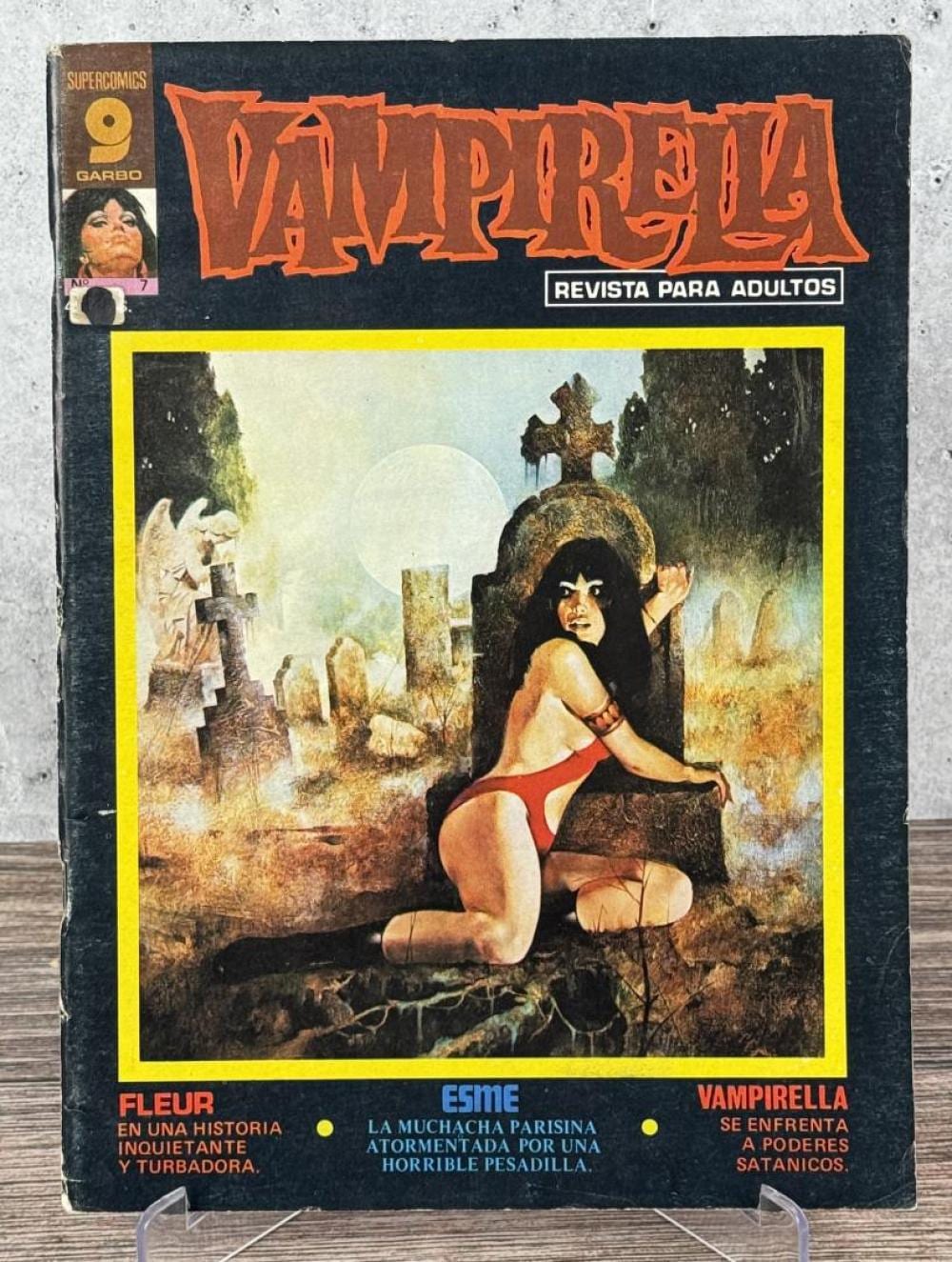Front cover of a Spanish comic book featuring the title “Vampirella” and a dark-haired woman in a red swimsuit kneeling on a grave in a cemetery scene.