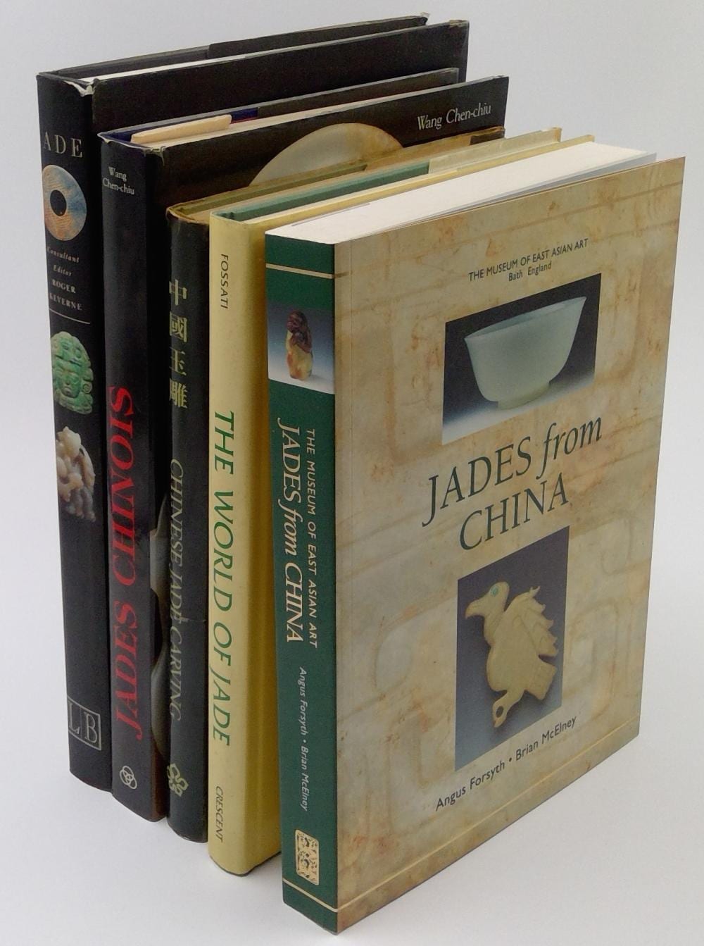Bookshelf photo showing several stacked books, including a pale yellow book titled “Jades from China” and spines reading “Thd Museum of East Asian Art” and “Shu