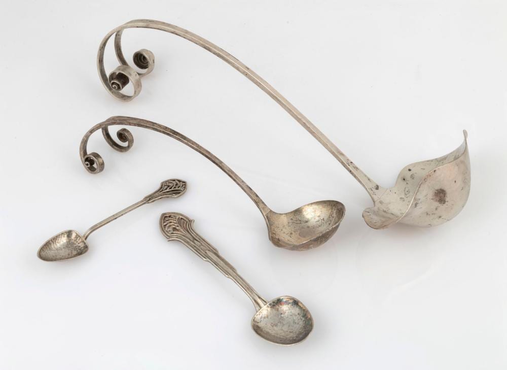 Set of four silver-colored ladles and spoons laid on a white background, with two long-handled sauce or soup spoons and two small spoons.