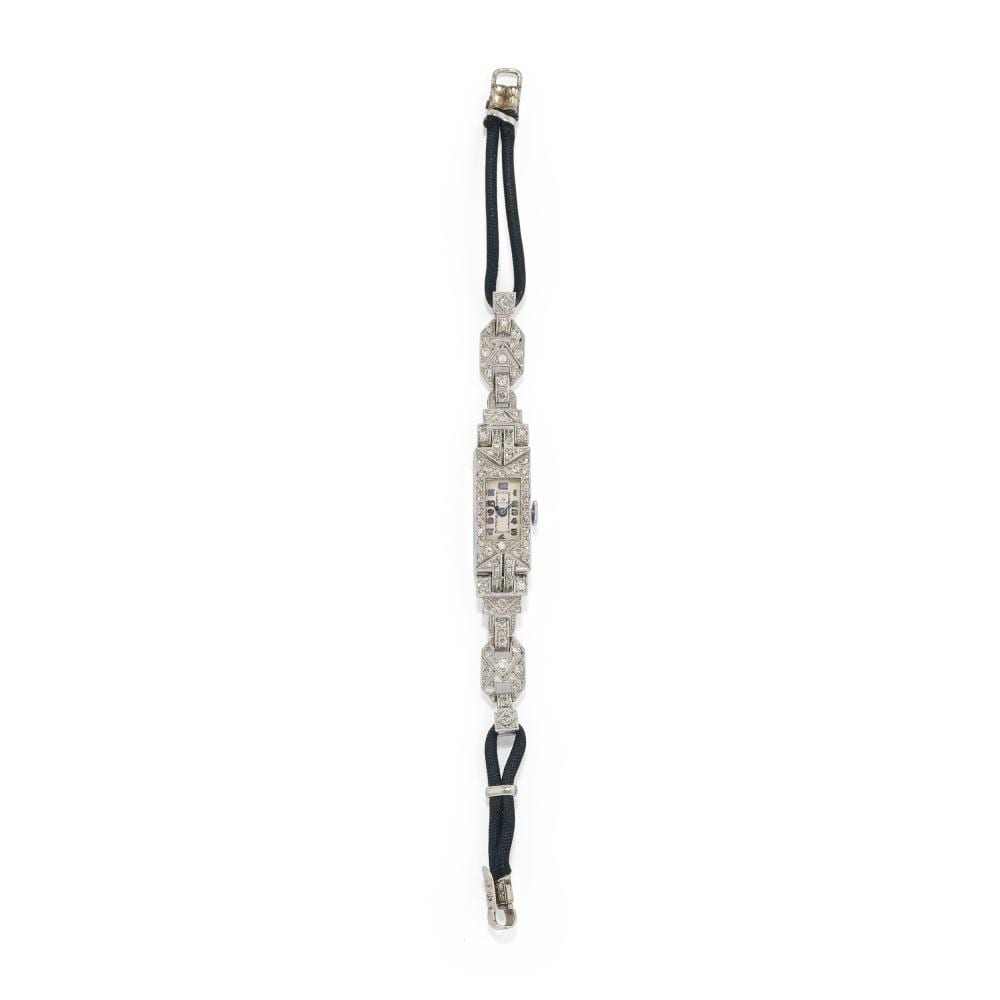 Diamond-studded platinum wristwatch with a rectangular face and dark leather strap, shown upright against a white background.