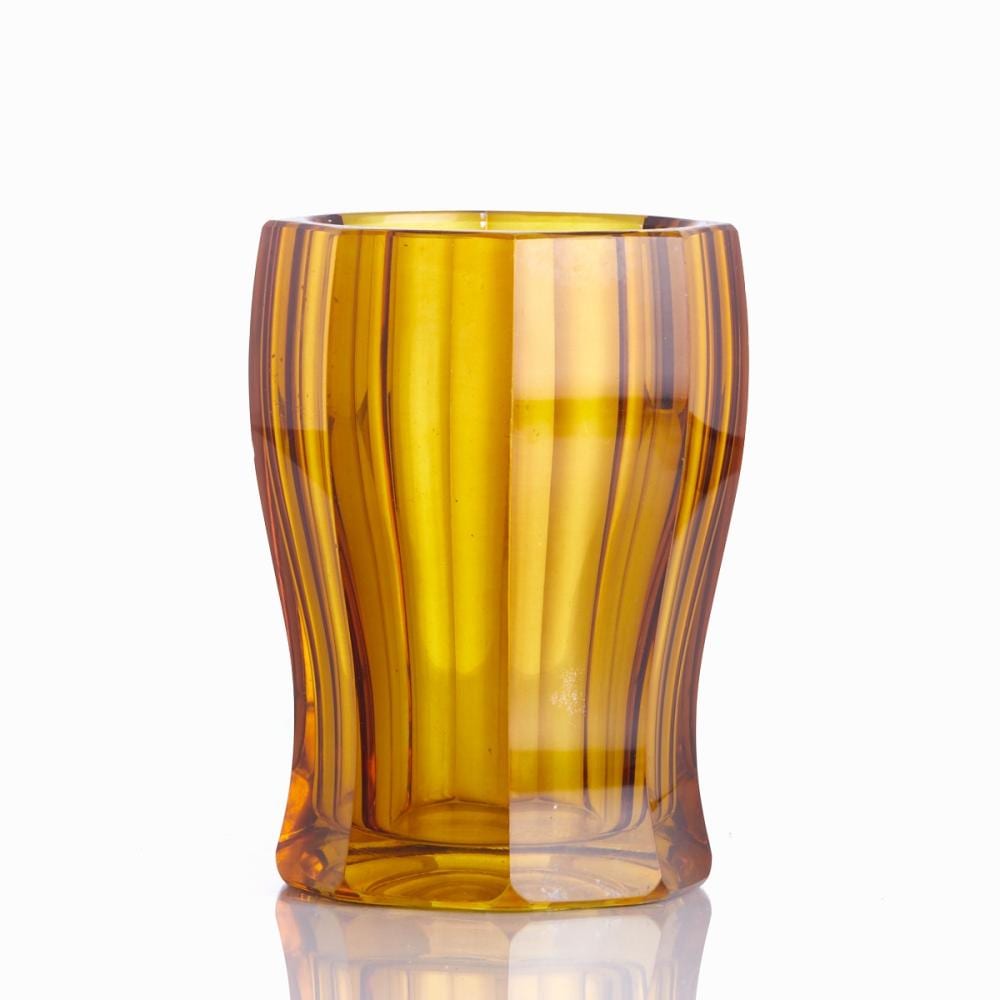 Amber glass vase with vertical ribbed stripes and a flared rim against a white background.
