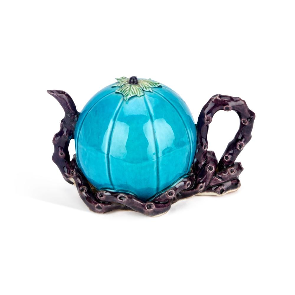 Turquoise glazed teapot with dark handles and spout, decorated with a small green leaf on the lid.