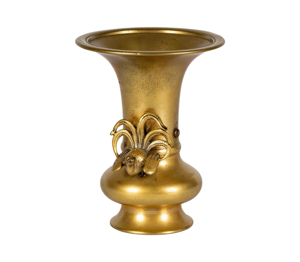 Brass vase with flared rim and decorative band of stylized leaves and animal figure relief on the front.