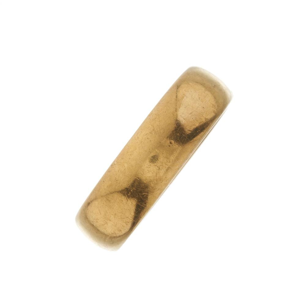 Close-up of a plain gold-colored ring band shown diagonally against a white background.