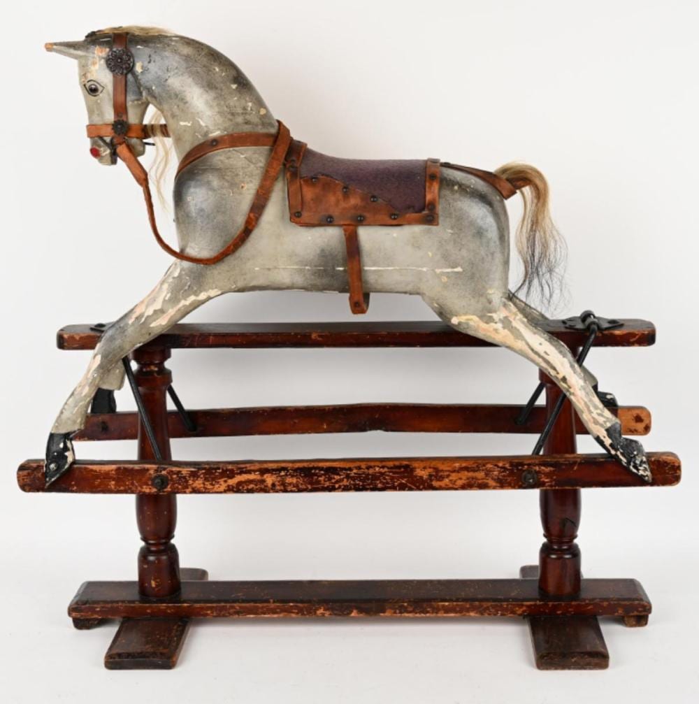Victorian-style wooden rocking horse with a gray painted body, brown saddle and harness, and a small mane