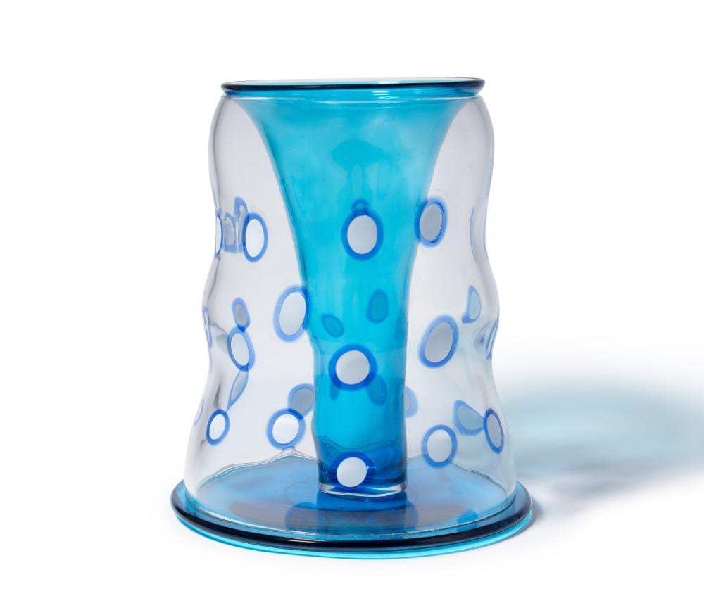 Blue and white glass vase with polka-dot decoration, wider rim at the top and flared sides narrowing at the base.