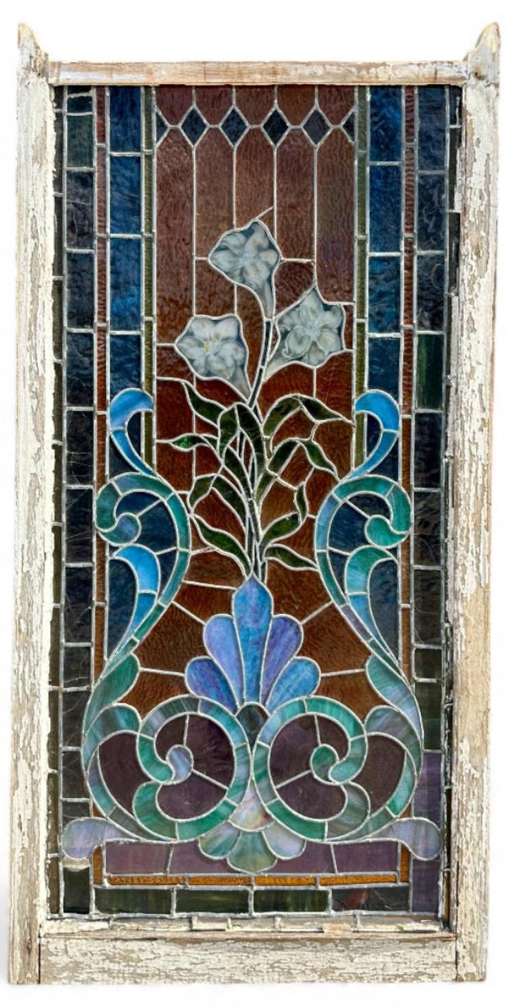 Antique stained glass window panel with blue and green floral motif, decorative heart-shaped corner elements, and leaded glass borders.
