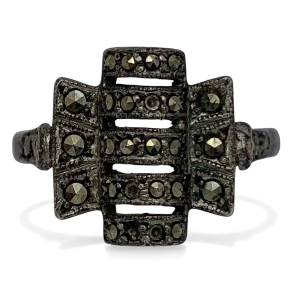 Sterling silver ring with a square, openwork centerpiece set with dark stones and lighter faceted accents.
