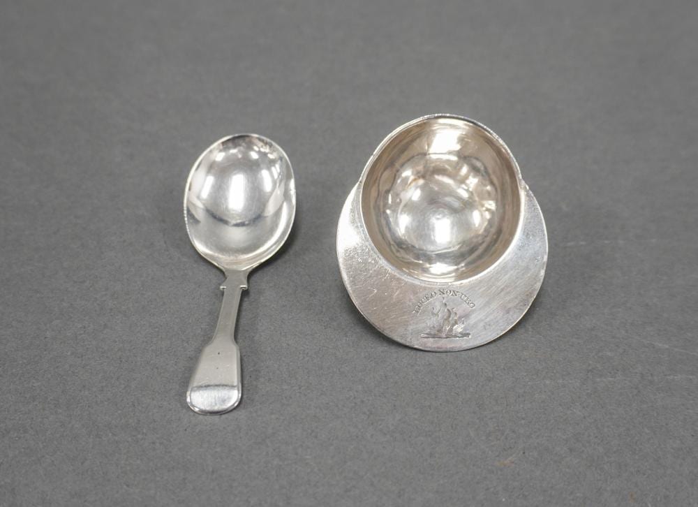 Sterling silver novelty caddy spoon with a small circular bowl and a larger circular base piece, shown on a gray background.