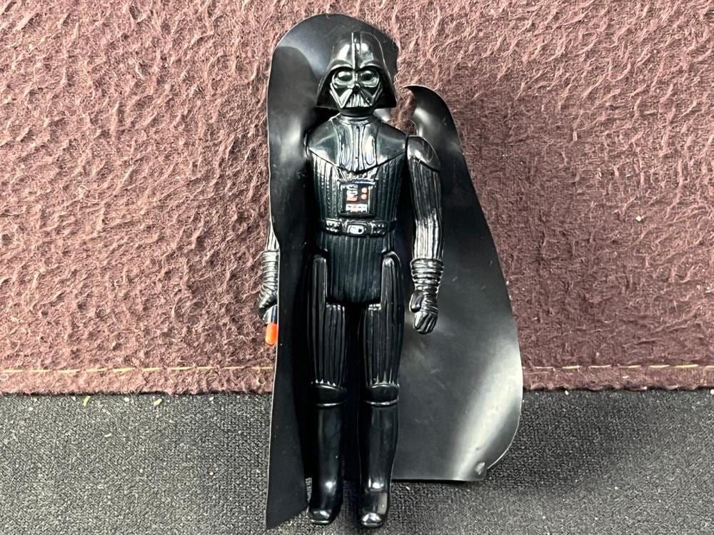 Black Darth Vader action figure standing with cape spread on a carpeted floor, facing forward.