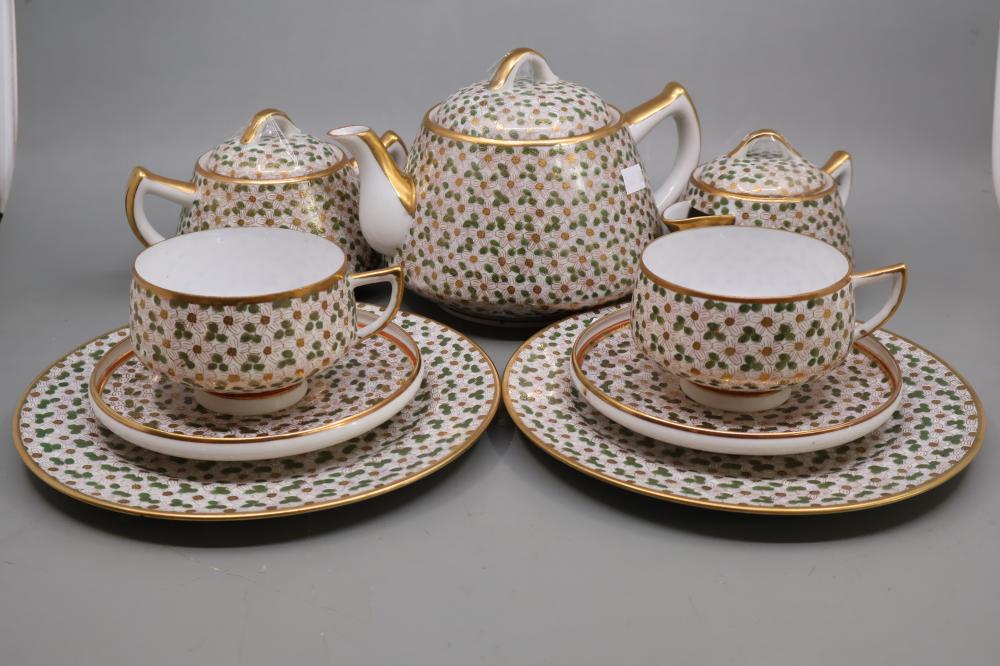 Five-piece Japanese-style Kutani tea set with patterned teapot and cups on saucers, featuring colorful dotted floral motifs and gold trim.