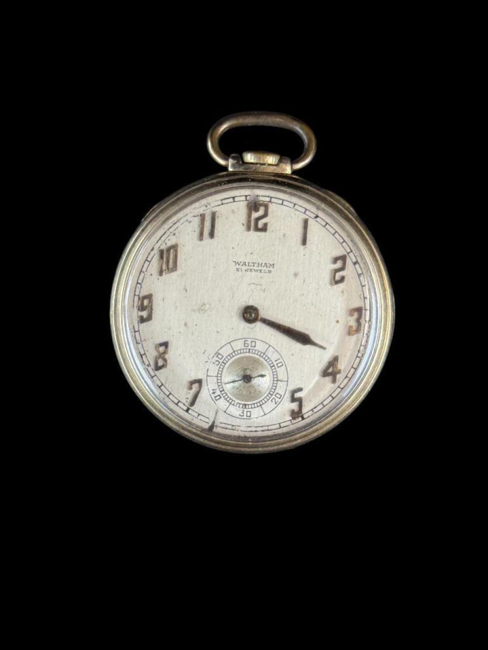 Front view of a gold-tone Waltham-style open-face pocket watch with a white dial, Roman numerals, and a small seconds subdial.