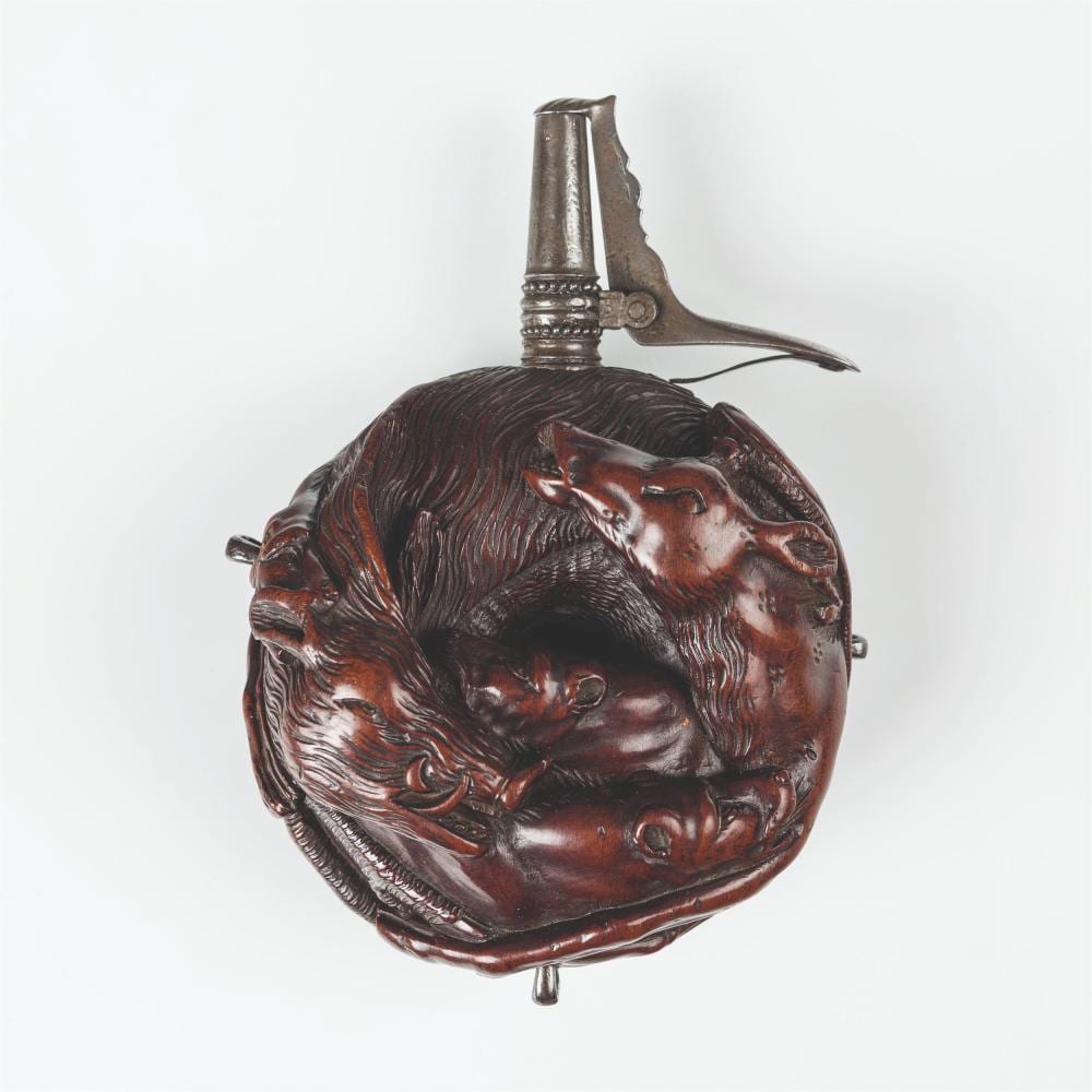 A rounded decorated powder flask with a narrow spout, in an auction photograph.
