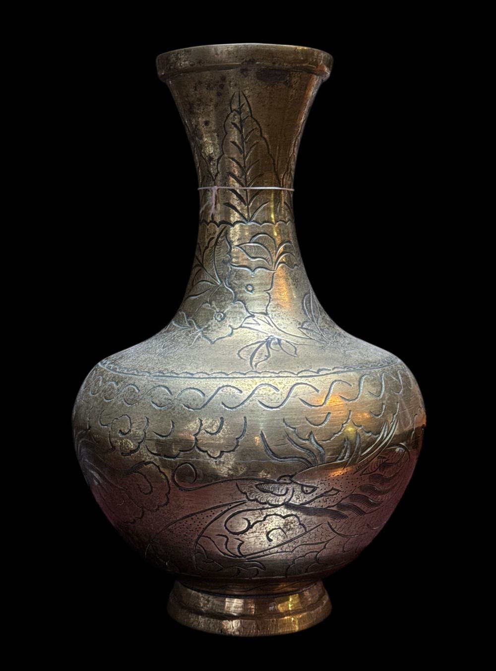 Metal vase with a flared neck and engraved dragon and leaf designs in gold and silver tones.