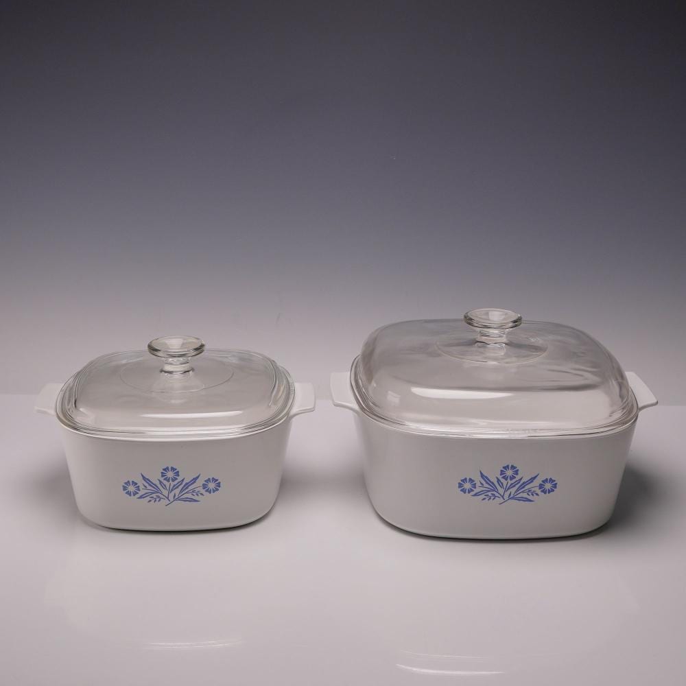 Two white casserole dishes with clear glass lids and blue cornflower-style floral decals on the front.