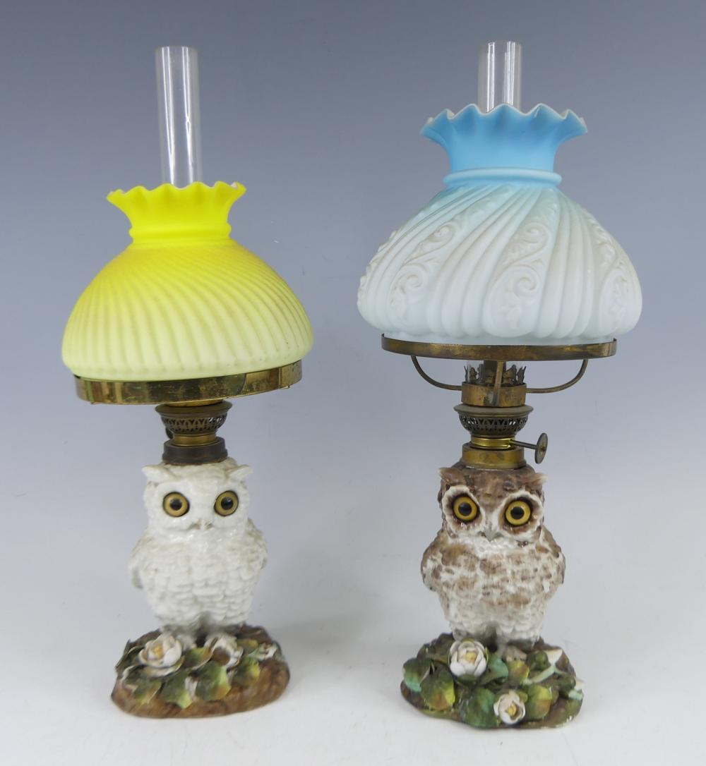 A matched pair of late Victorian owl porcelain oil lamps, having moulded glass shades, each owl upon a floral encrusted rocky outcrop, each with impressed registration lozenge marks verso, h.34cm sold by Lacy Scott & Knight, lot 2340 — auction record photograph