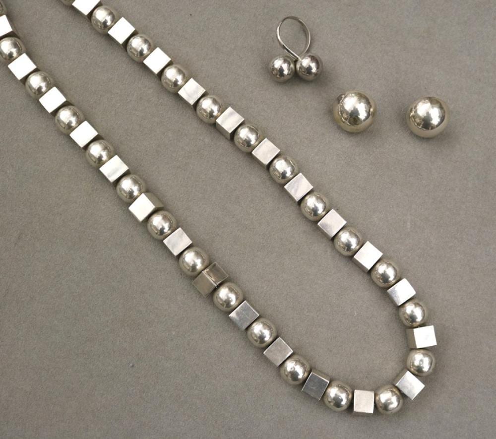 Silver beaded bracelet with alternating round balls and square blocks, plus matching silver earrings and stud-like spheres on a gray background.