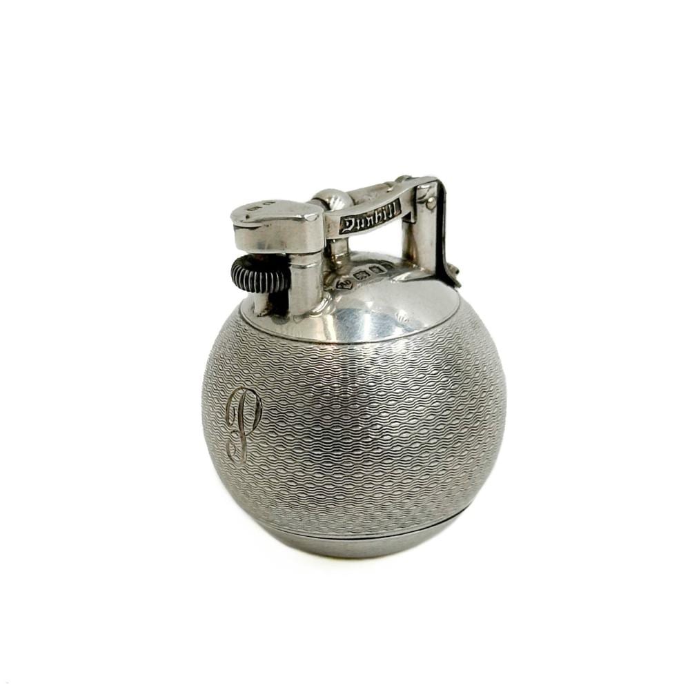 Close-up of a silver-toned ball-shaped pocket lighter with a hinged top and textured body design.