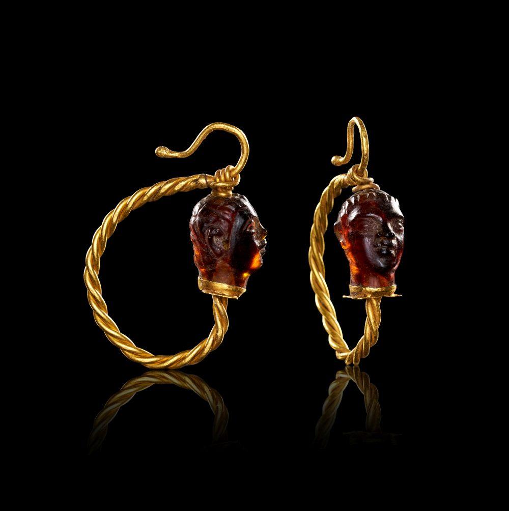 A PAIR OF ROMAN TWISTED GOLD & GARNET FACIAL EARRINGS, CIRCA 2ND-3RD CENTURY A.D. sold by PLAKAS, lot 428 — auction record photograph