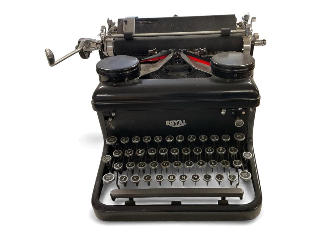 Vintage black typewriter with round keys and a centered “ROYAL” logo on the front panel.
