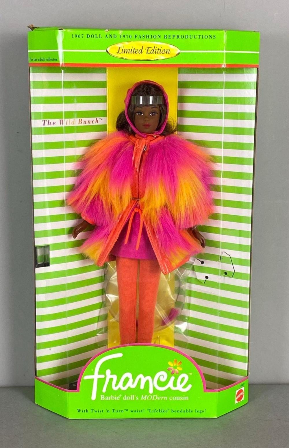 Boxed fashion doll with a hood and multicolored fuzzy coat on a colorful striped package.