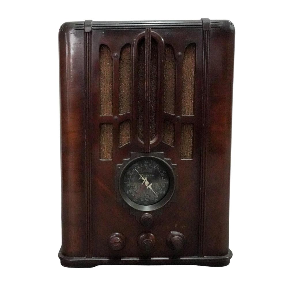 Dark brown vintage tombstone-style radio with a circular dial and three round control knobs across the front.