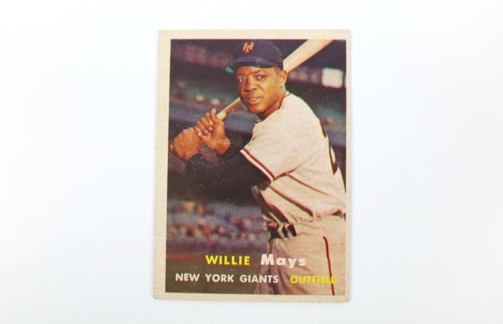 Baseball trading card featuring Willie Mays in a white New York Giants uniform with a bat and stadium background.
