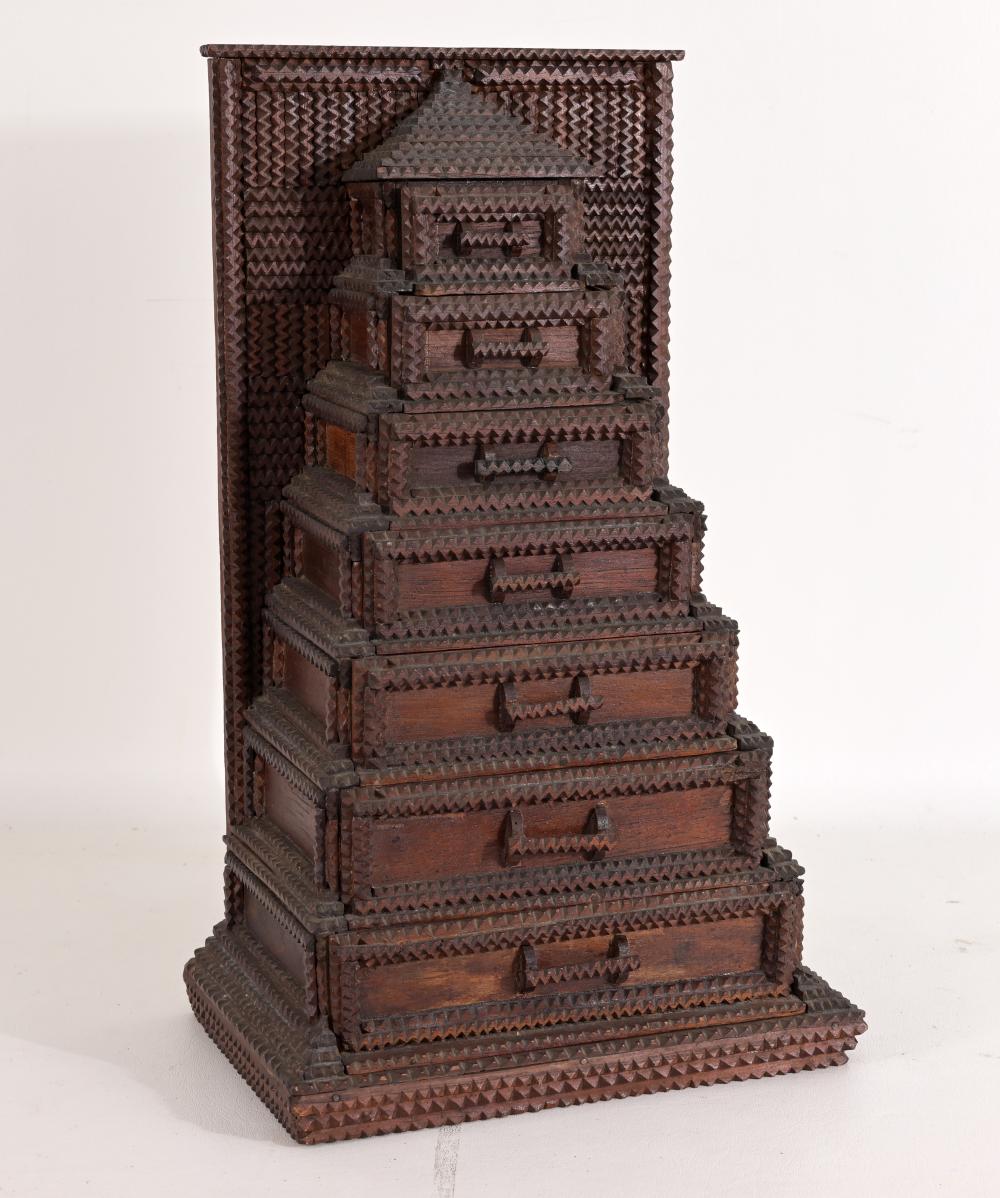 Antique-style wooden jewelry box with stepped drawers and zigzag carved panels, viewed from the front.