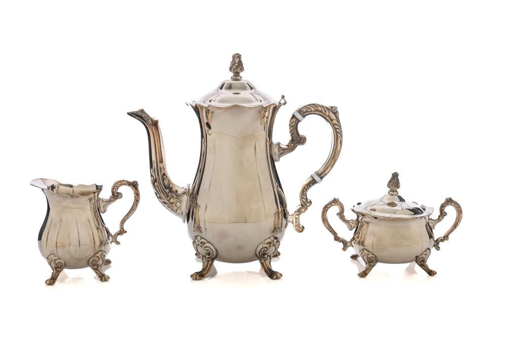 Silver-plated rococo-style tea set with a tall teapot, creamer jug, sugar bowl, and matching lids on a white background.