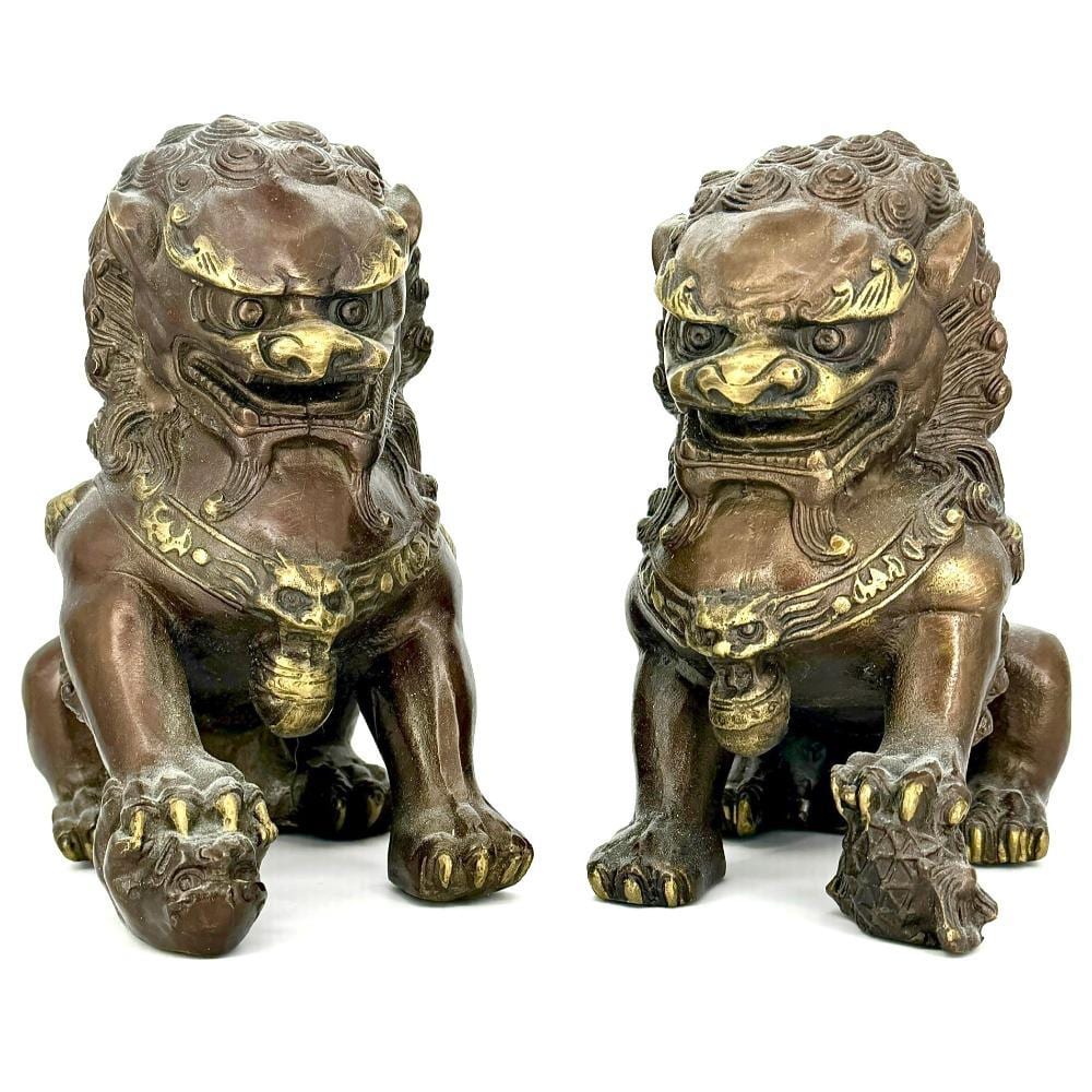 Pair of bronze Chinese guardian foo dog lion statues with raised hair curls, snarling faces, and gold accents.