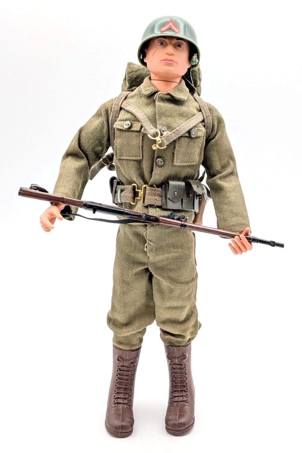 Vintage-style action figure of a soldier wearing a green uniform, helmet, and boots, holding a rifle across the front.
