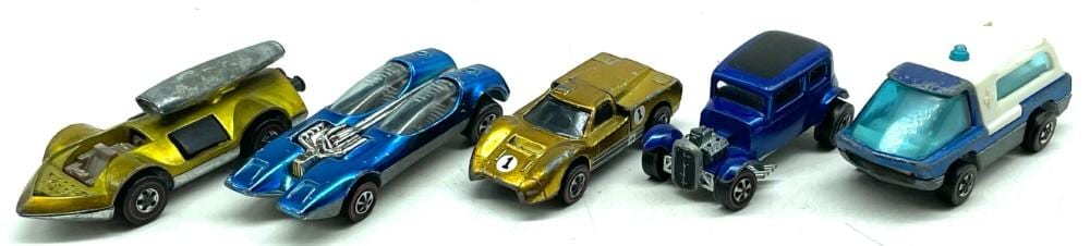 Five vintage-style toy cars on a white background, including yellow, blue, gold, black-and-blue, and white/blue vehicles.