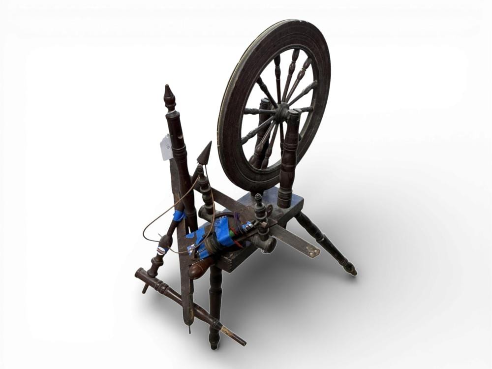 Antique wooden spinning wheel with a large circular wheel, multi-spoke drive, and extended metal spindle holder on a white background.