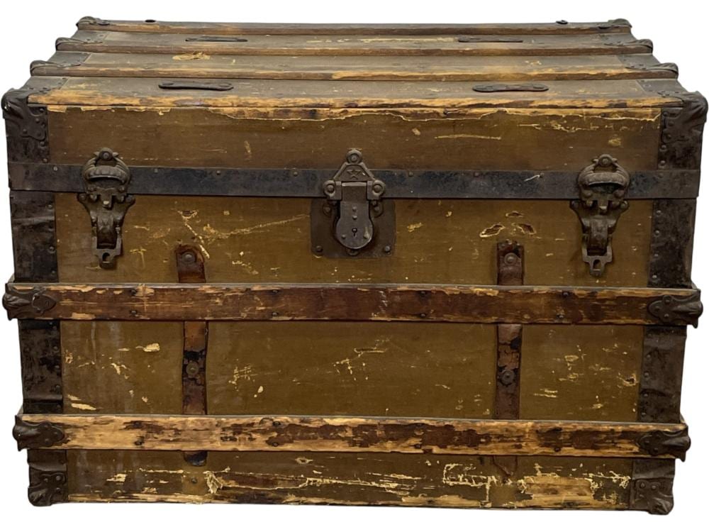 Vintage brown steamer trunk with metal corner fittings and latch handles, shown front view.