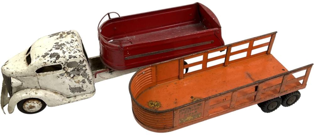 Vintage toy truck and trailer in white and orange with a red bed, shown on a plain background.